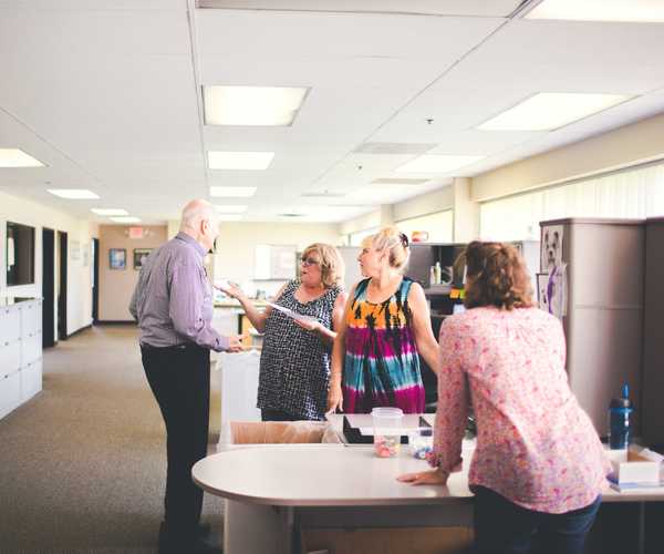 i-deal optics team members discussing in office