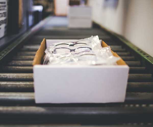 conveyor belt with boxes of eyeglasses on it