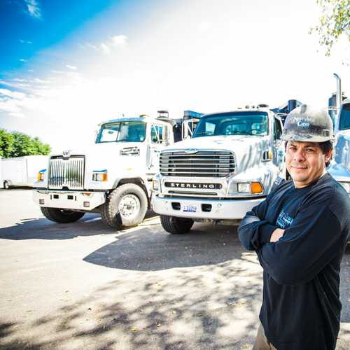 Man in hard hat standing in front of trucks